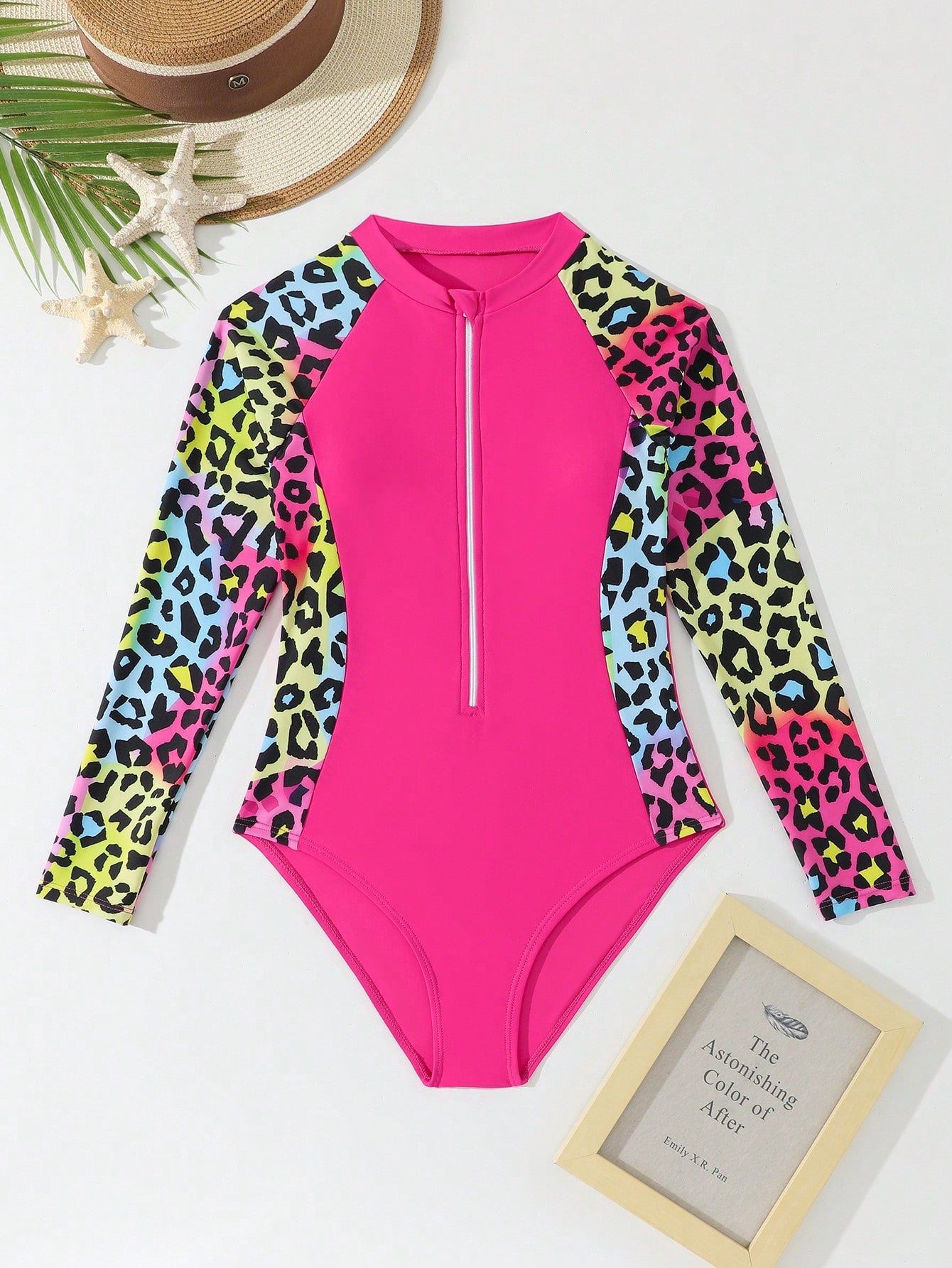 Girls one-piece swimsuit in blue with all-over leopard leaf print, ruffle detail, zipper front, high neck, and lined body for swimming and vacation.