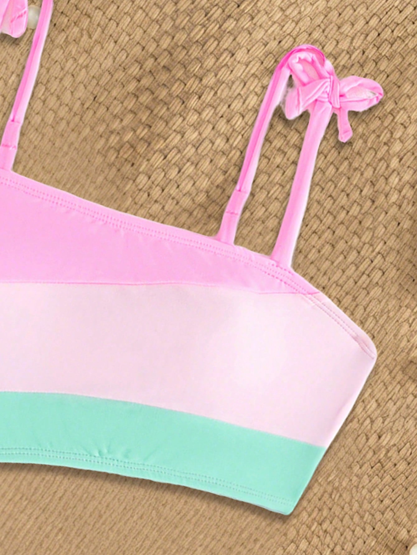 Pink colorblock one-piece swimsuit for tween girls with spaghetti straps, cut-out detail, lined body, and mid-waist bottom for swimming, beach, and vacation wear.
