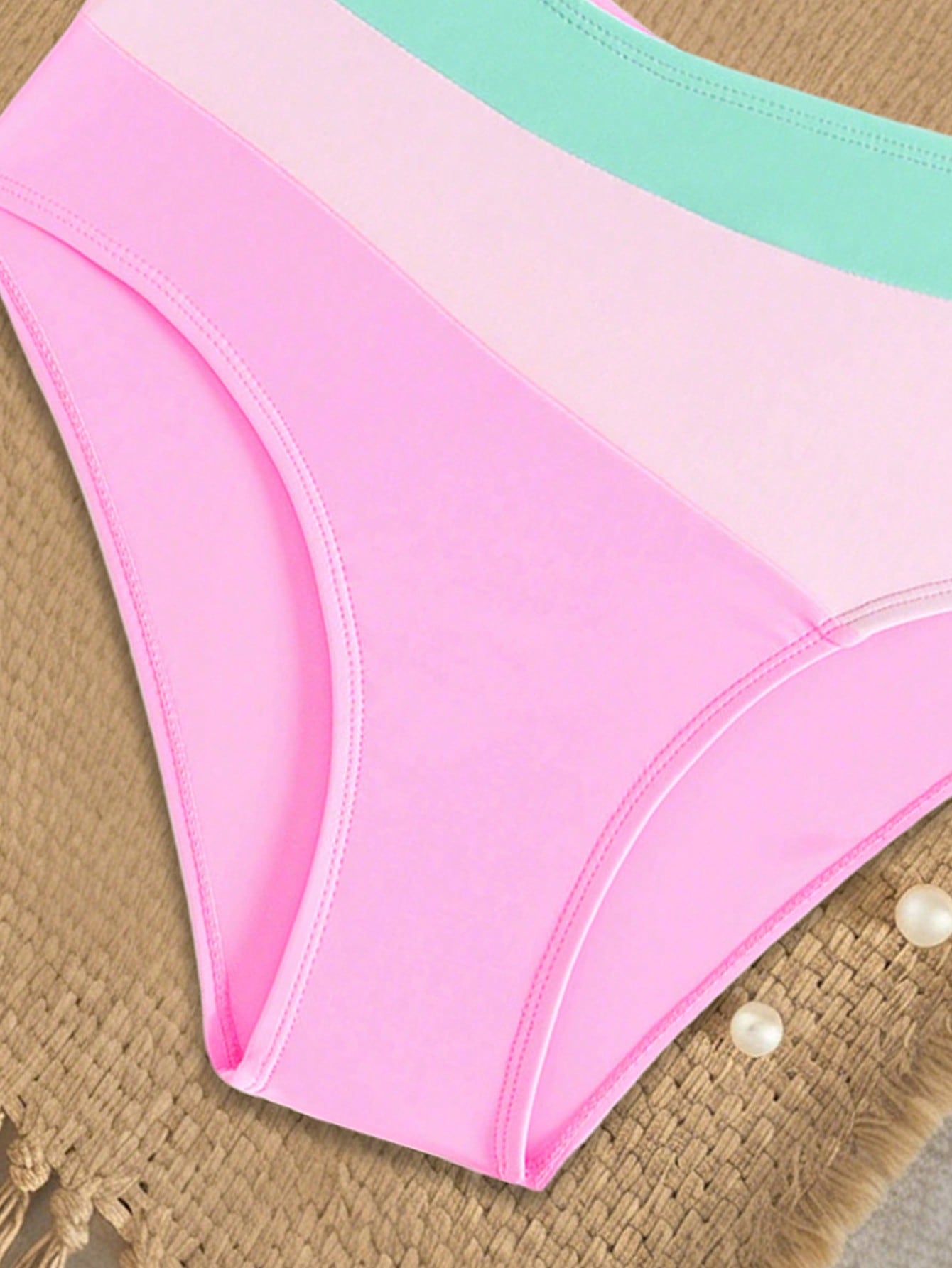 Pink colorblock one-piece swimsuit for tween girls with spaghetti straps, cut-out detail, lined body, and mid-waist bottom for swimming, beach, and vacation wear.