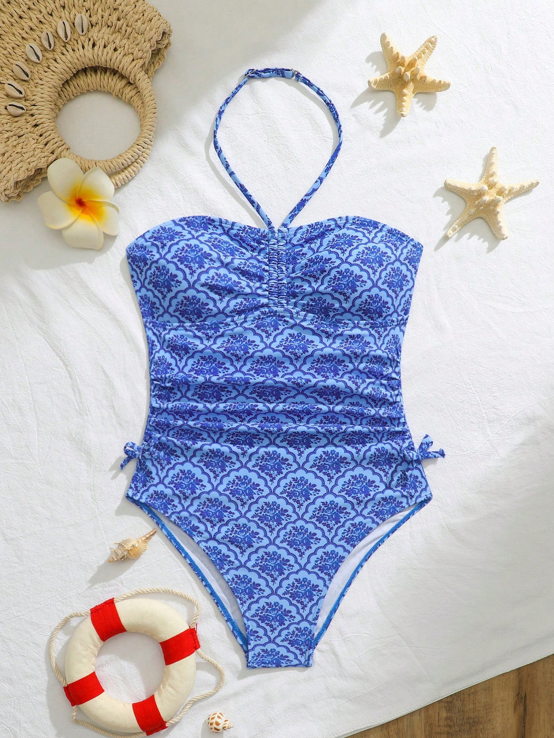 Blue halter one-piece swimsuit for tween girls with full geometric print, wireless bra design, mid-waist bottom, and medium-stretch fabric for beach and pool wear.