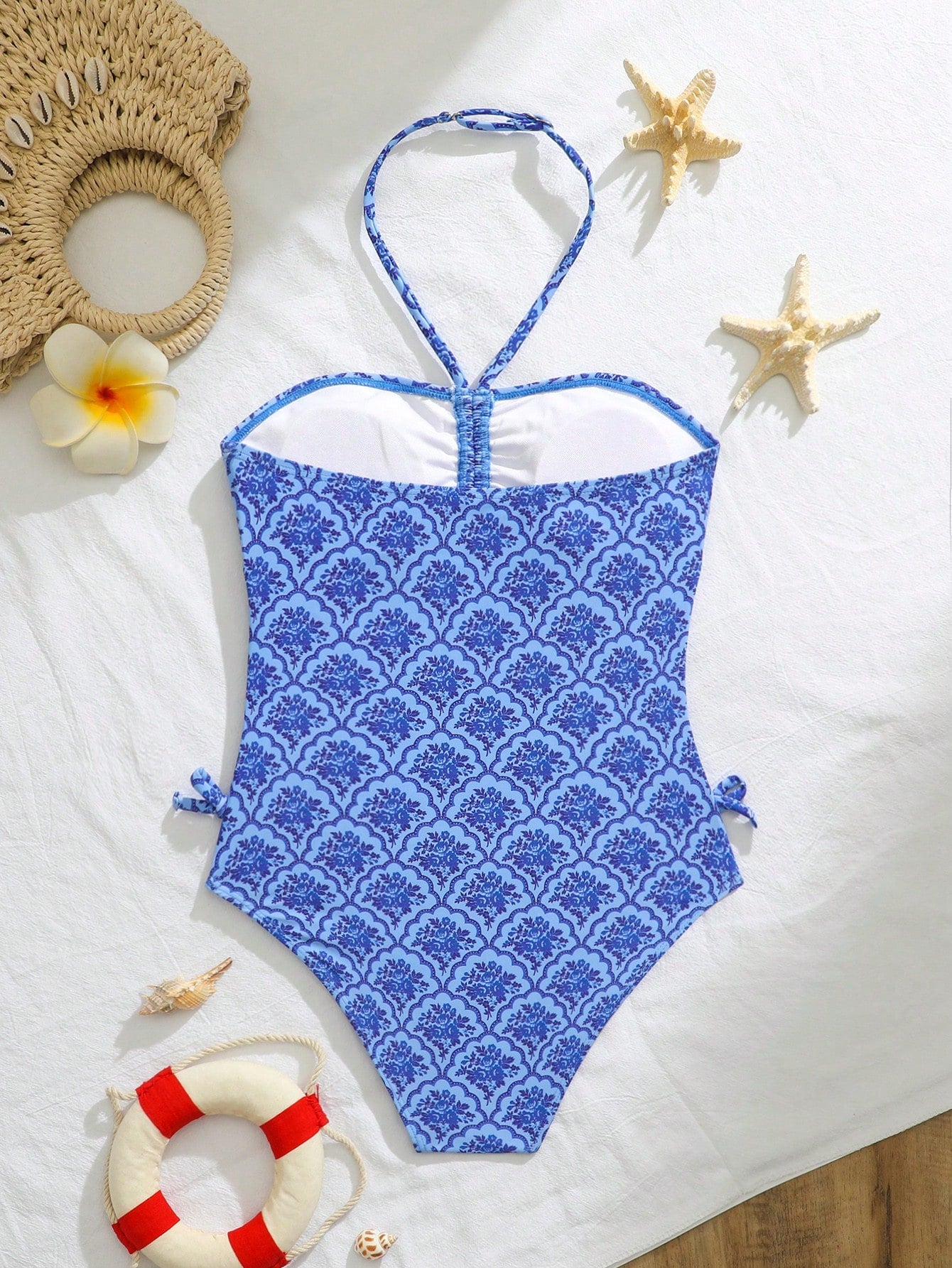 Blue halter one-piece swimsuit for tween girls with full geometric print, wireless bra design, mid-waist bottom, and medium-stretch fabric for beach and pool wear.