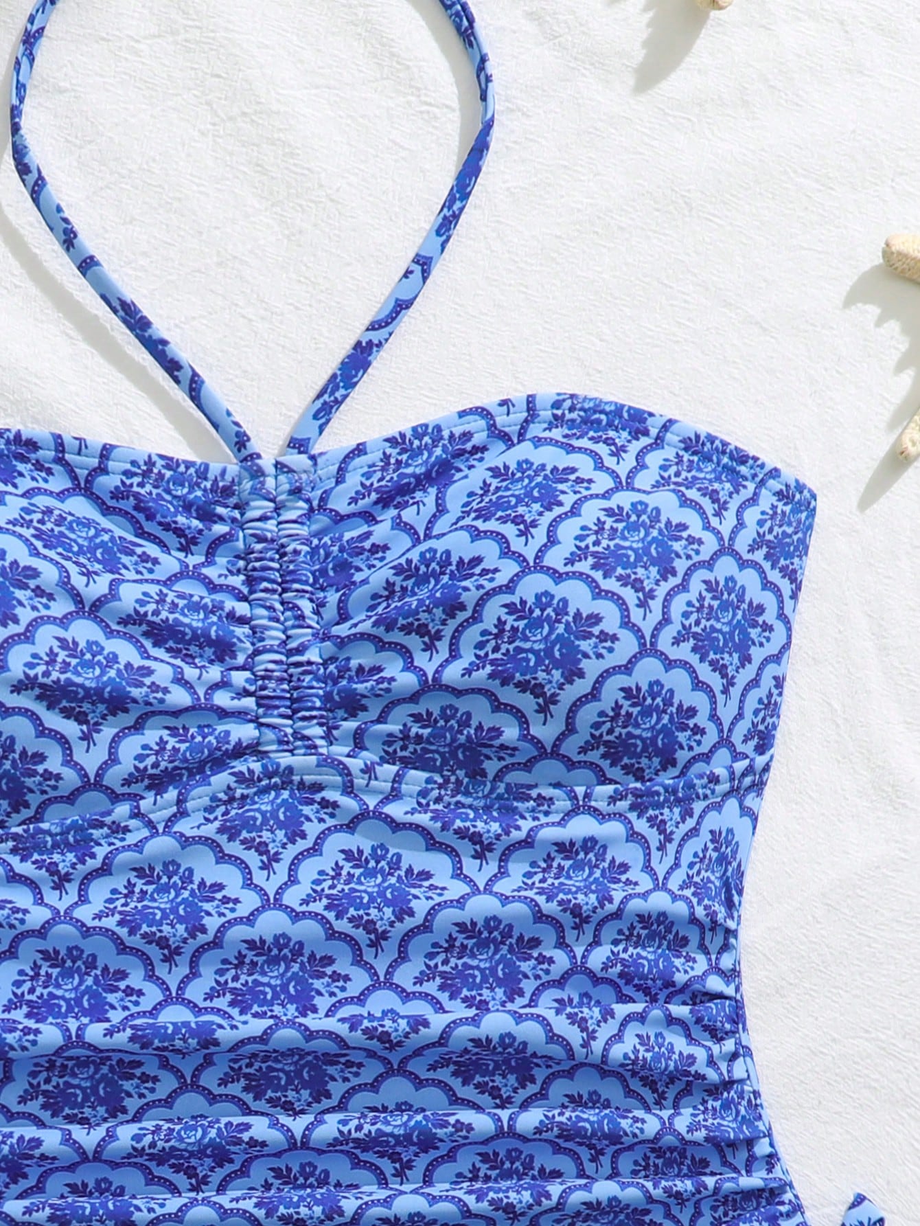 Blue halter one-piece swimsuit for tween girls with full geometric print, wireless bra design, mid-waist bottom, and medium-stretch fabric for beach and pool wear.