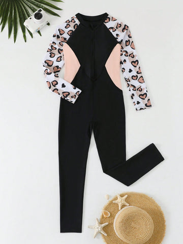 Tween girls black one-piece swimsuit with long sleeves, high neck, zipper detail, graphic leopard heart print, and fitted full-coverage swimwear style.