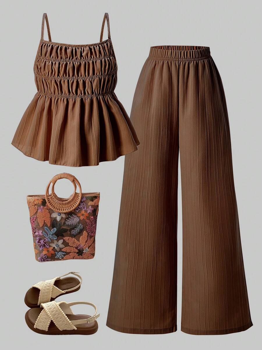 Tween girl wearing an apricot 2-piece outfit set featuring a shirred spaghetti strap short cami top and matching wide-leg long pants.