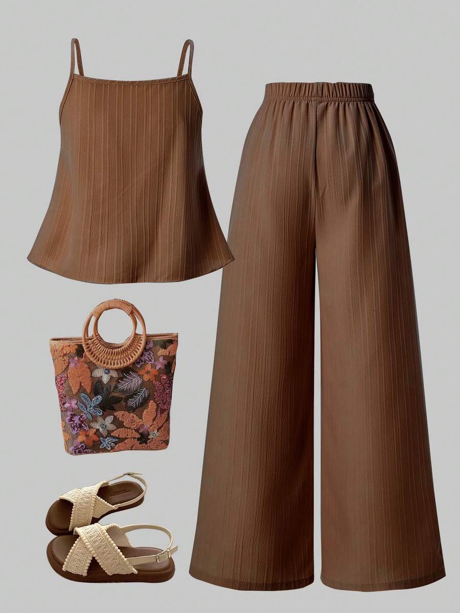Tween girl wearing an apricot 2-piece outfit set featuring a shirred spaghetti strap short cami top and matching wide-leg long pants.