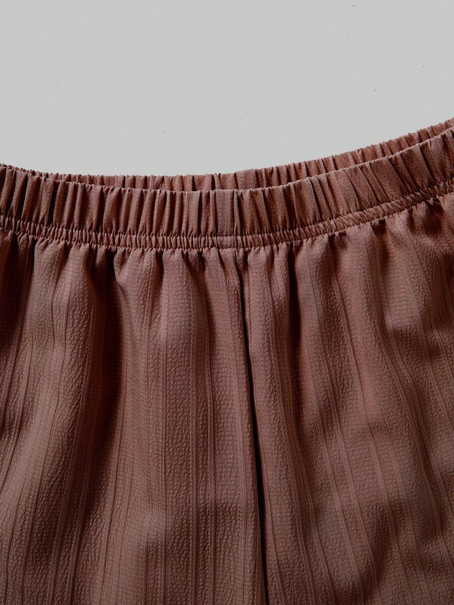 Tween girl wearing an apricot 2-piece outfit set featuring a shirred spaghetti strap short cami top and matching wide-leg long pants.
