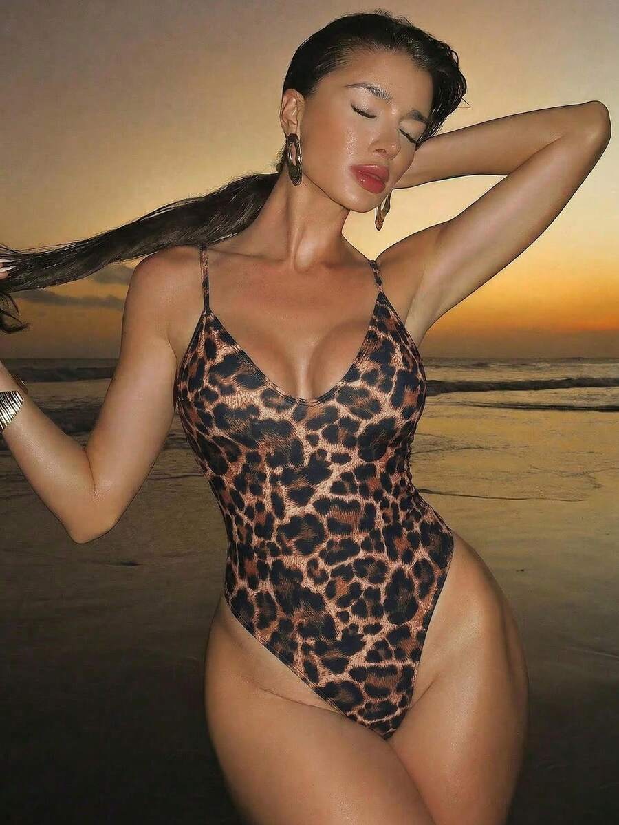 Women's black lace one-piece swimsuit featuring a deep V-neckline, spaghetti straps, backless tie-up detail, and thong bottom.