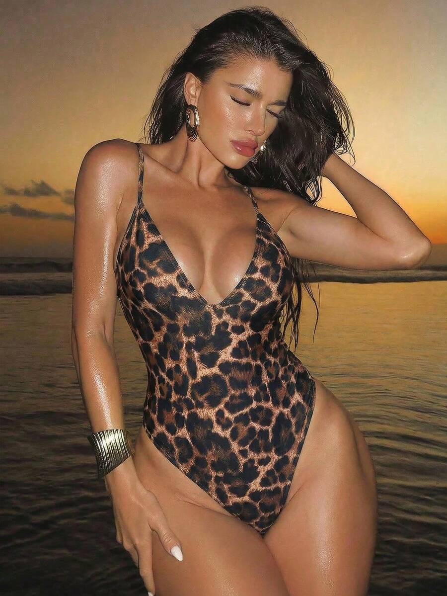 Women's black lace one-piece swimsuit featuring a deep V-neckline, spaghetti straps, backless tie-up detail, and thong bottom.