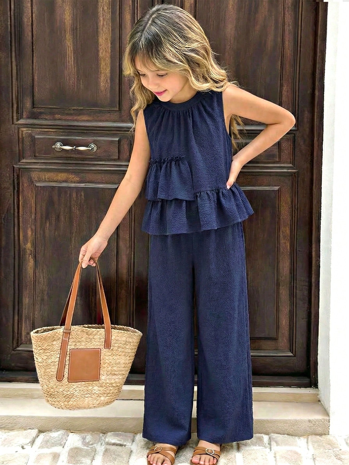 Tween girls blue striped sleeveless short top with button and ruffle details paired with matching long straight leg pants.