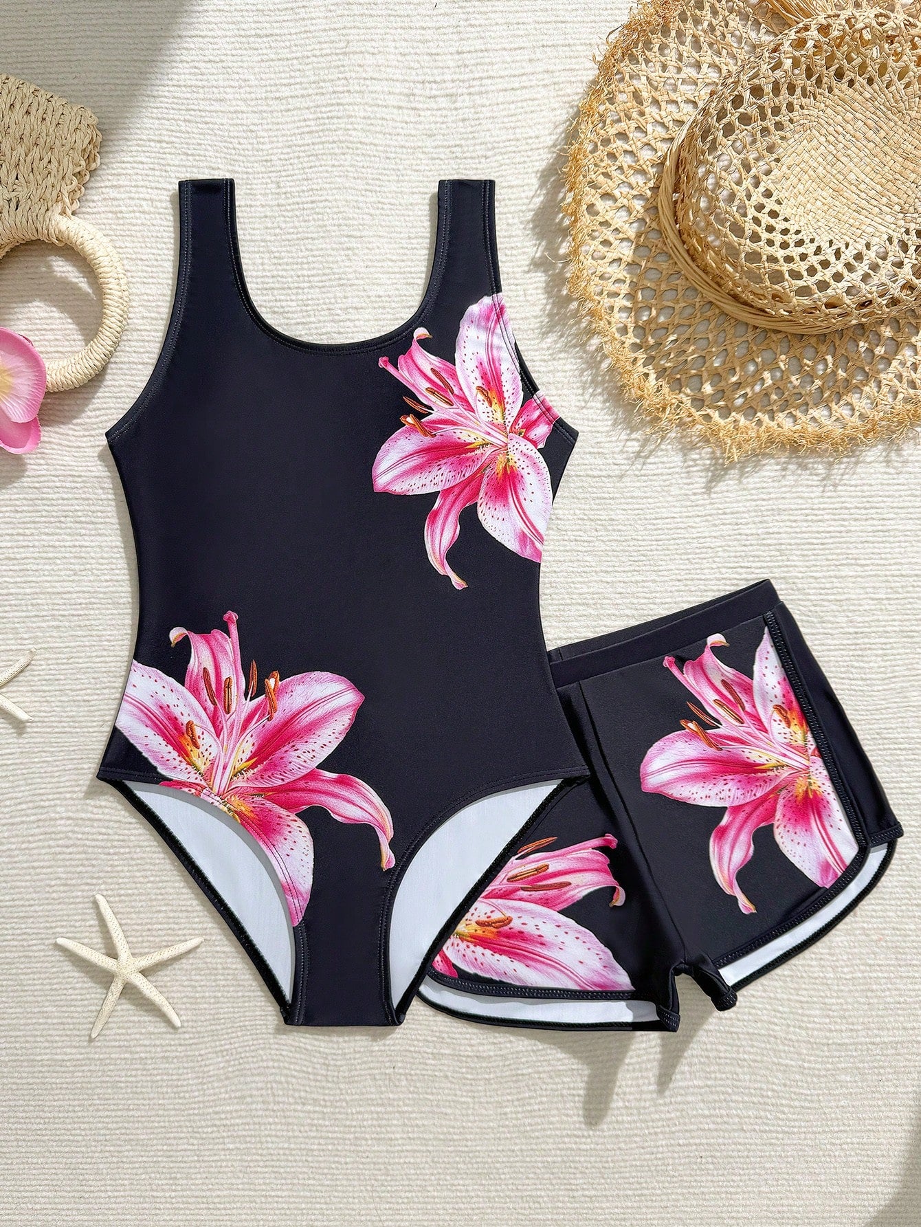 Tween girls 2-piece swimsuit set in black with full floral and plant print, featuring a sleeveless scoop-neck swim top and matching shorts-style bottoms.