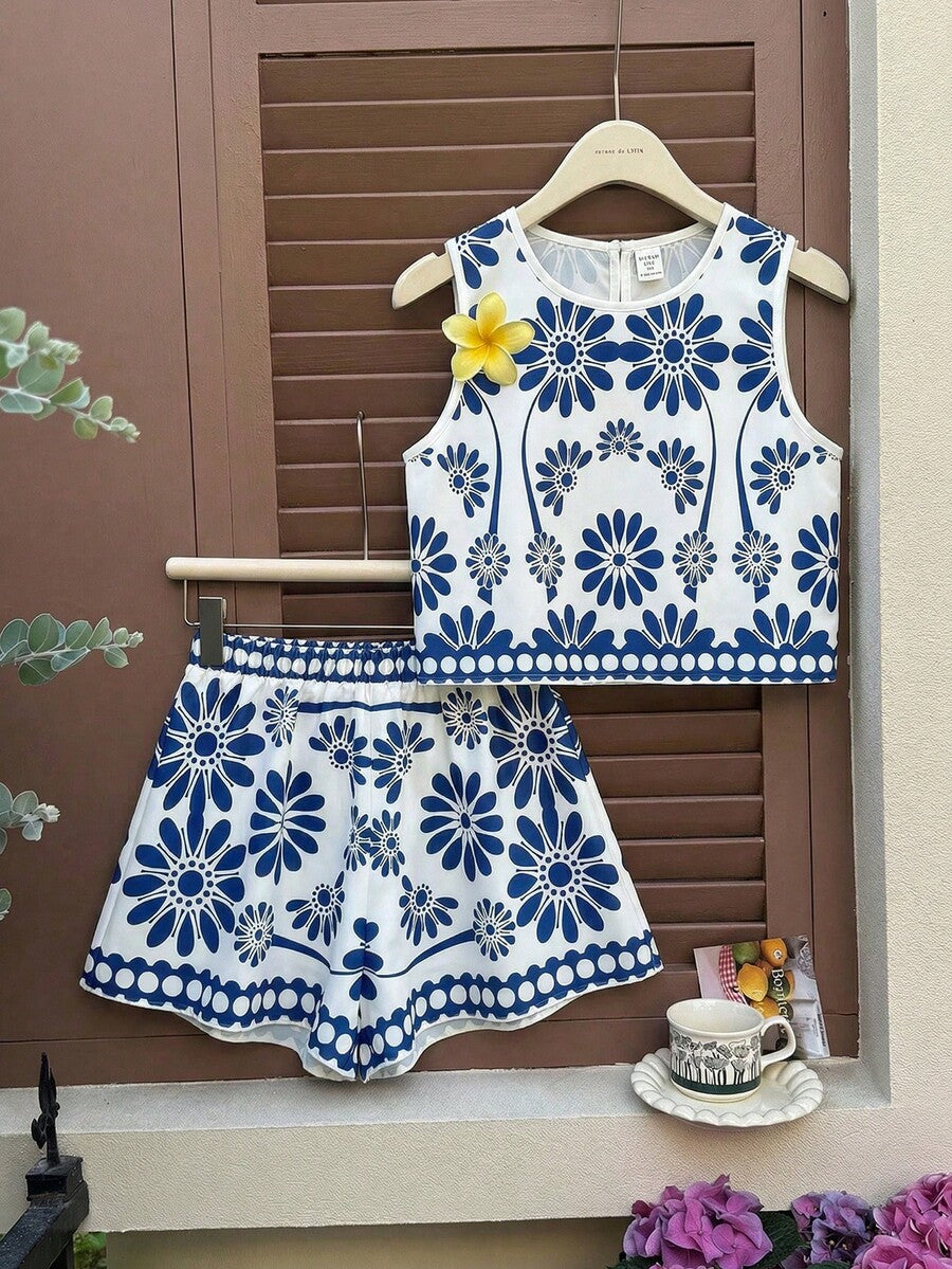 Tween girl wearing a tropical floral print two-piece vacation set featuring a sleeveless round neck tank top with button details and matching shorts.