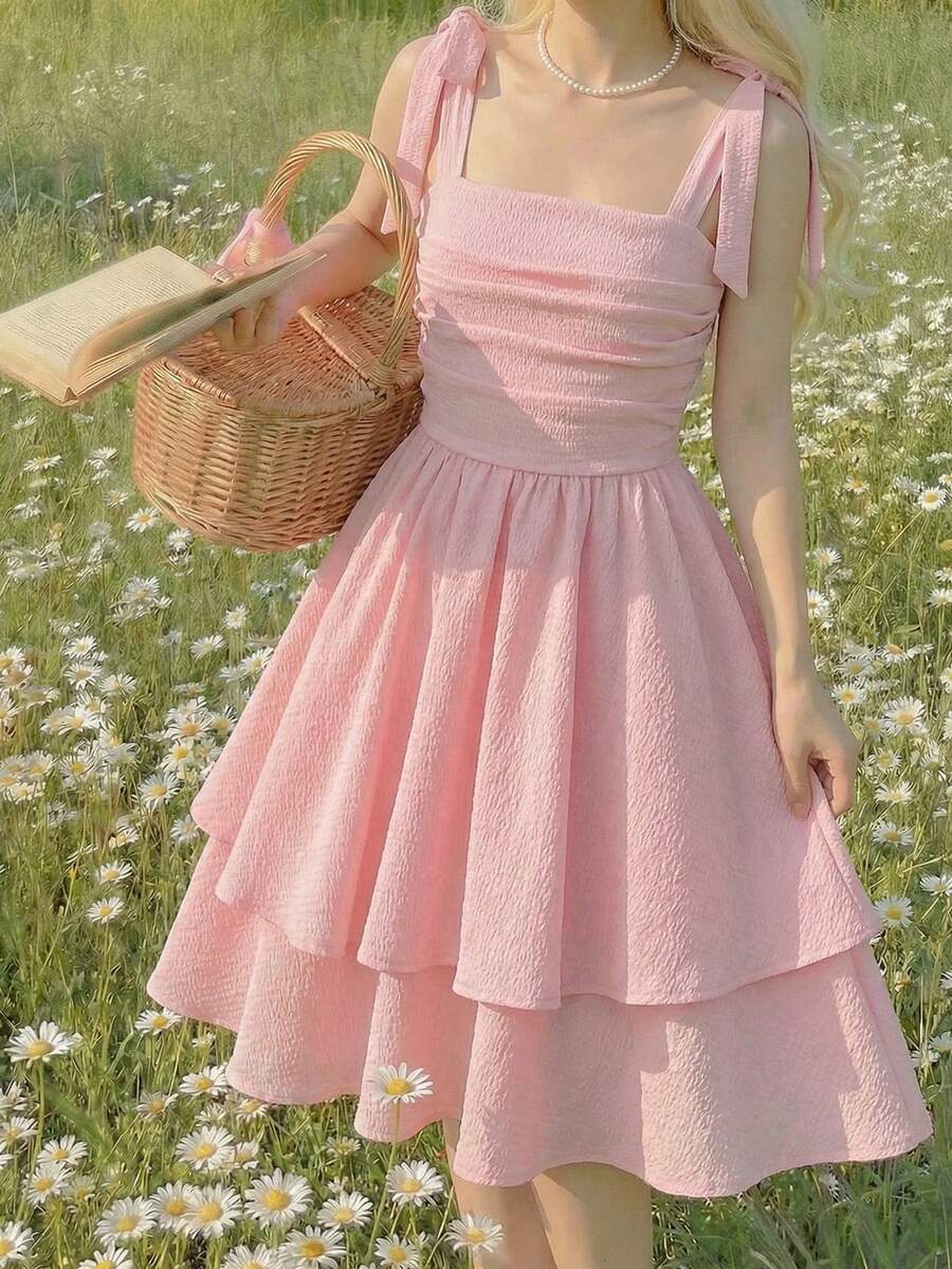 Tween girl wearing a pink tiered off-the-shoulder midi dress with shirred high waist and layered hem