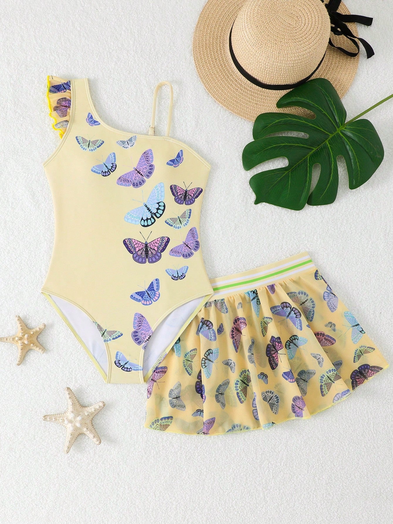 Girls yellow one-piece swimsuit with asymmetrical neckline, ruffle detail, sleeveless fitted style, and skirt bottom for beach and pool vacations.