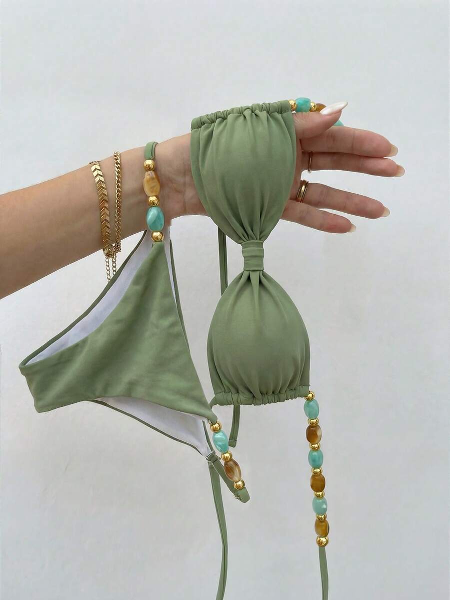 Women's green halter neck bikini set featuring color-block beaded shoulder straps, back tie detail, and high cut bottoms.