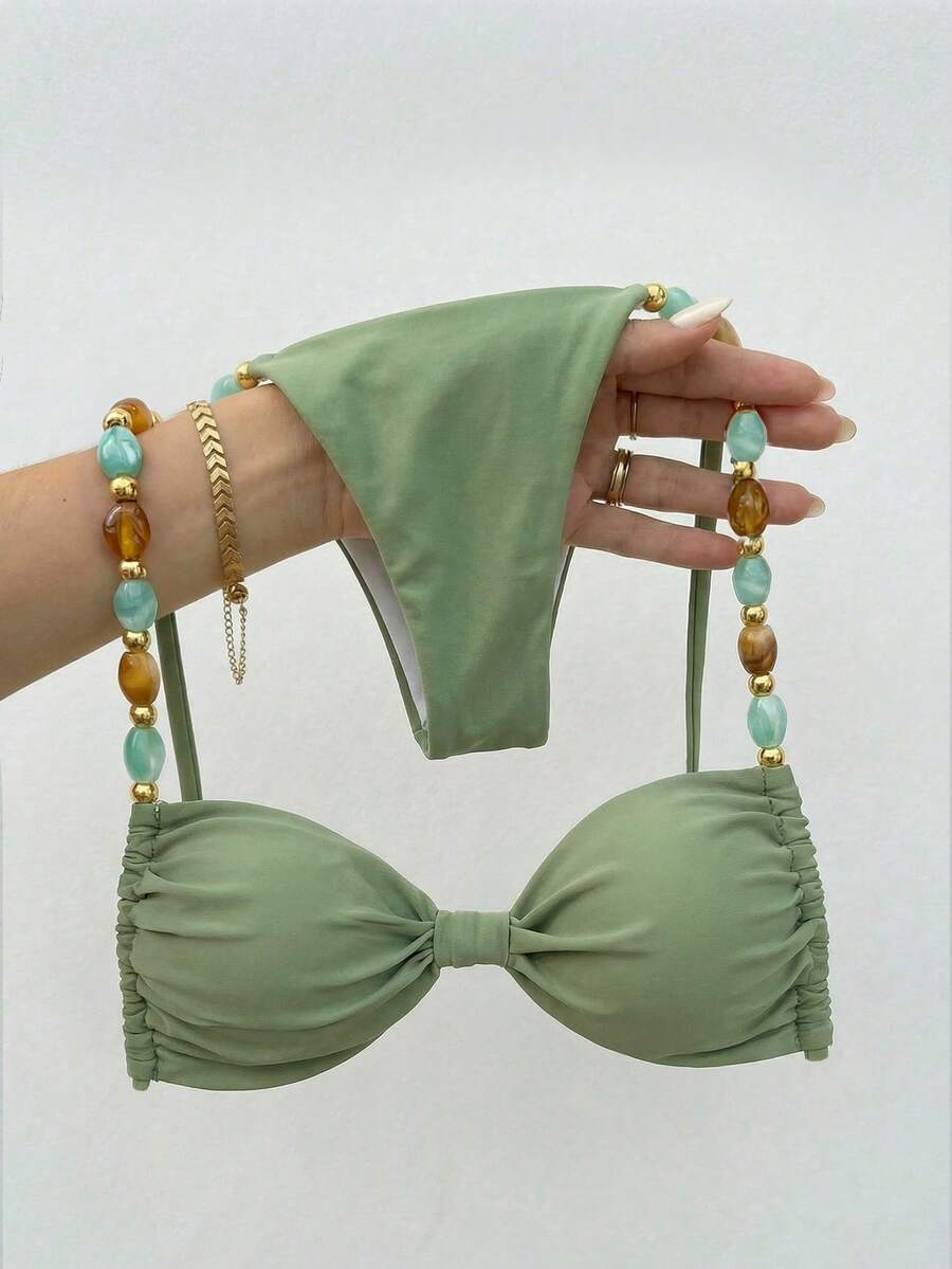 Women's green halter neck bikini set featuring color-block beaded shoulder straps, back tie detail, and high cut bottoms.