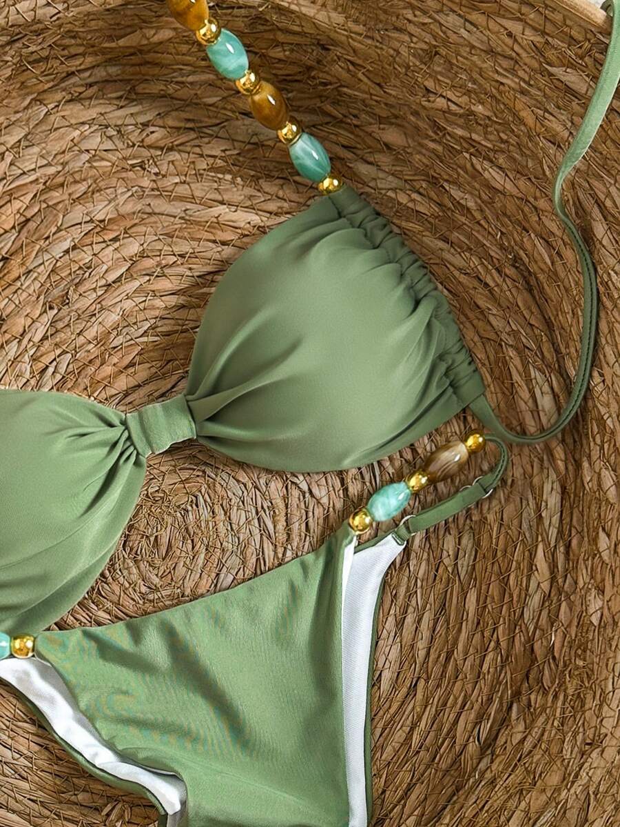 Women's green halter neck bikini set featuring color-block beaded shoulder straps, back tie detail, and high cut bottoms.
