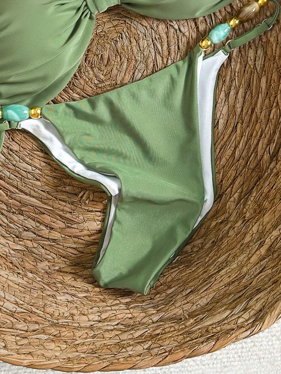 Women's green halter neck bikini set featuring color-block beaded shoulder straps, back tie detail, and high cut bottoms.