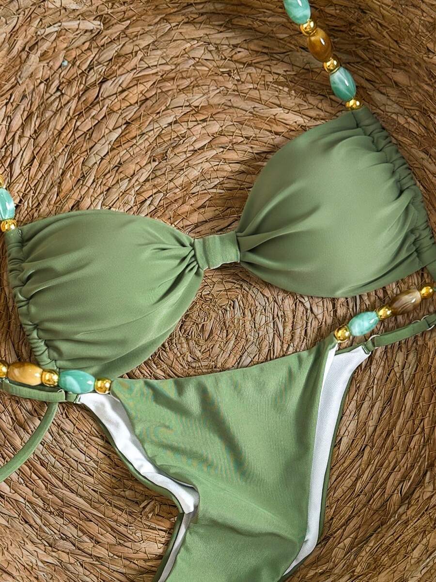 Women's green halter neck bikini set featuring color-block beaded shoulder straps, back tie detail, and high cut bottoms.
