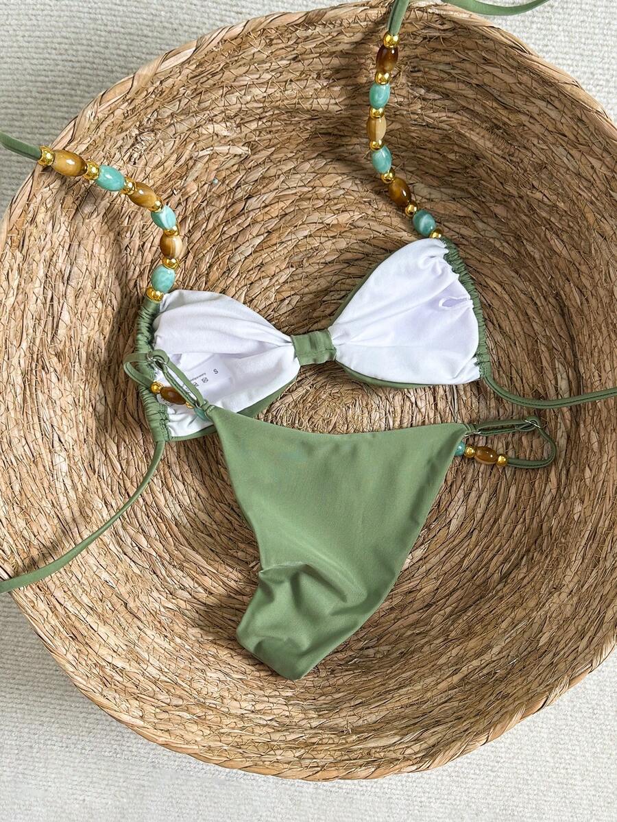 Women's green halter neck bikini set featuring color-block beaded shoulder straps, back tie detail, and high cut bottoms.