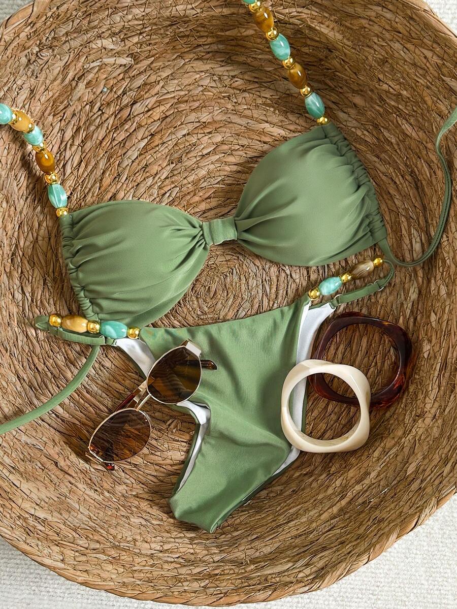 Women's green halter neck bikini set featuring color-block beaded shoulder straps, back tie detail, and high cut bottoms.