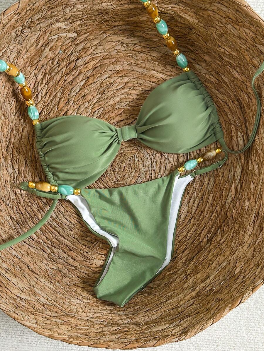 Women's green halter neck bikini set featuring color-block beaded shoulder straps, back tie detail, and high cut bottoms.