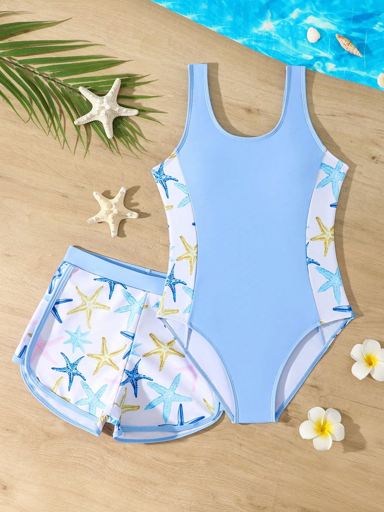 Tween girls 2-piece swimsuit set in black with full floral and plant print, featuring a sleeveless scoop-neck swim top and matching shorts-style bottoms.