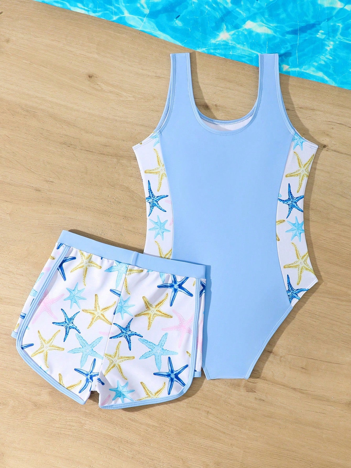 Tween girls 2-piece swimsuit set in black with full floral and plant print, featuring a sleeveless scoop-neck swim top and matching shorts-style bottoms.