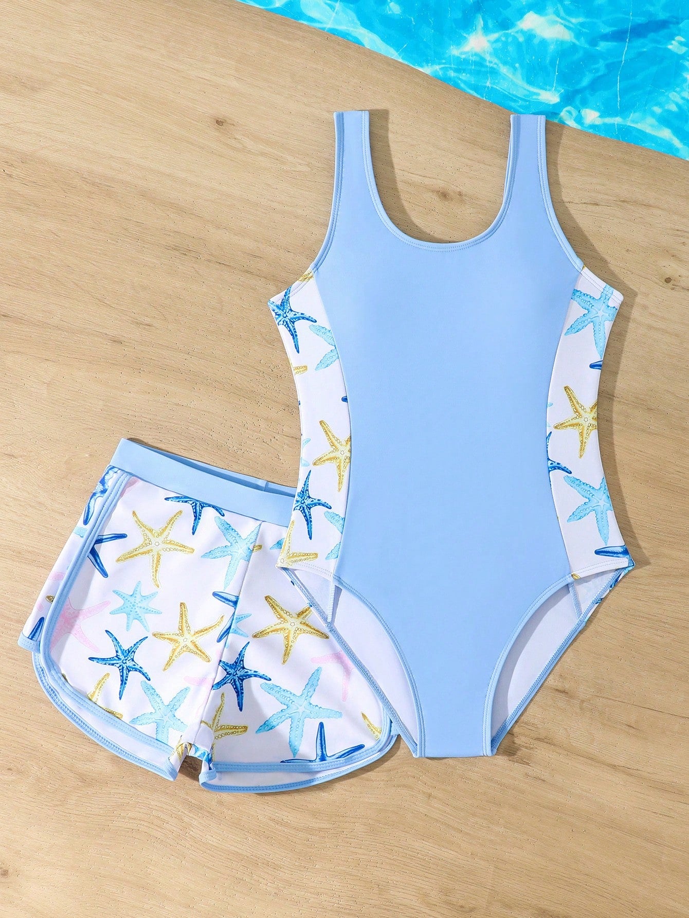 Tween girls 2-piece swimsuit set in black with full floral and plant print, featuring a sleeveless scoop-neck swim top and matching shorts-style bottoms.