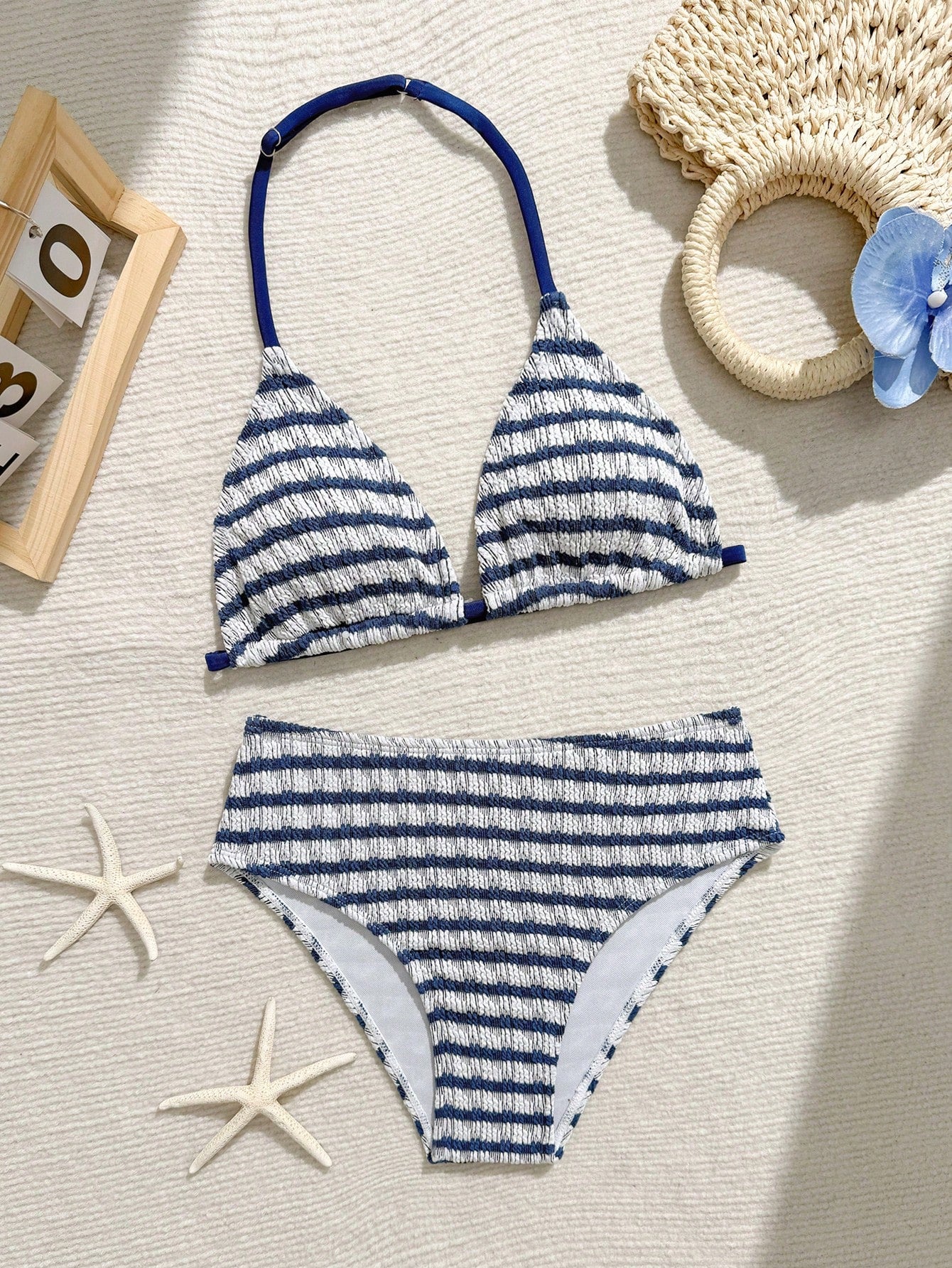Tween girls blue and white striped two-piece bikini set with halter triangle top and mid-waist short bikini bottoms for beach and vacation swimwear.