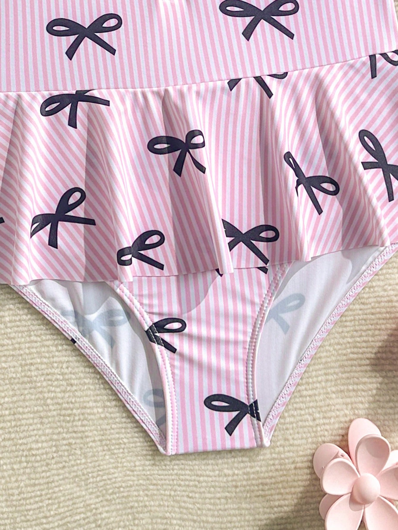 Purple tween girls one-piece swimsuit with graphic striped print, ruffle detail, round neck, and zipper closure for swimming and vacation wear