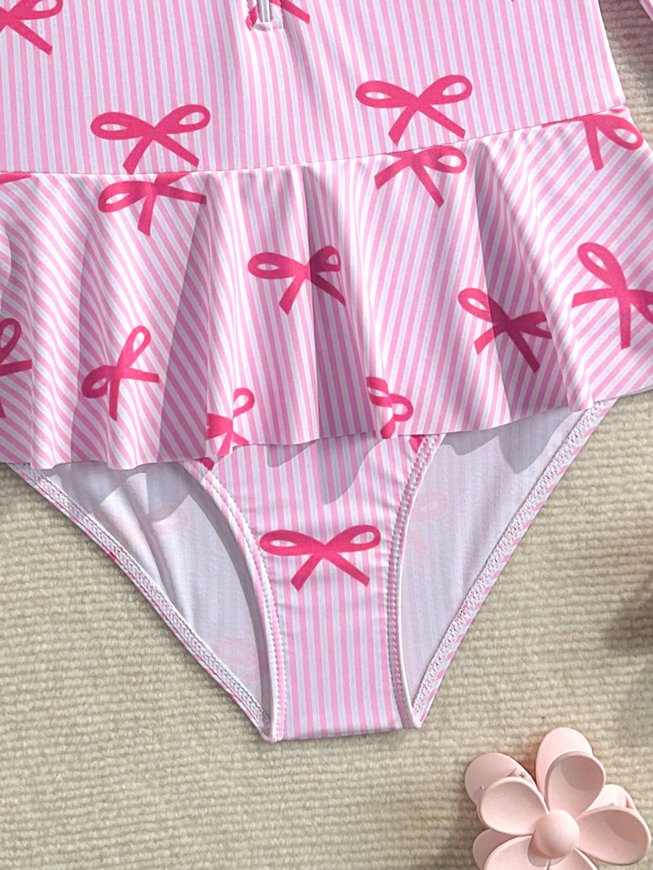 Purple tween girls one-piece swimsuit with graphic striped print, ruffle detail, round neck, and zipper closure for swimming and vacation wear