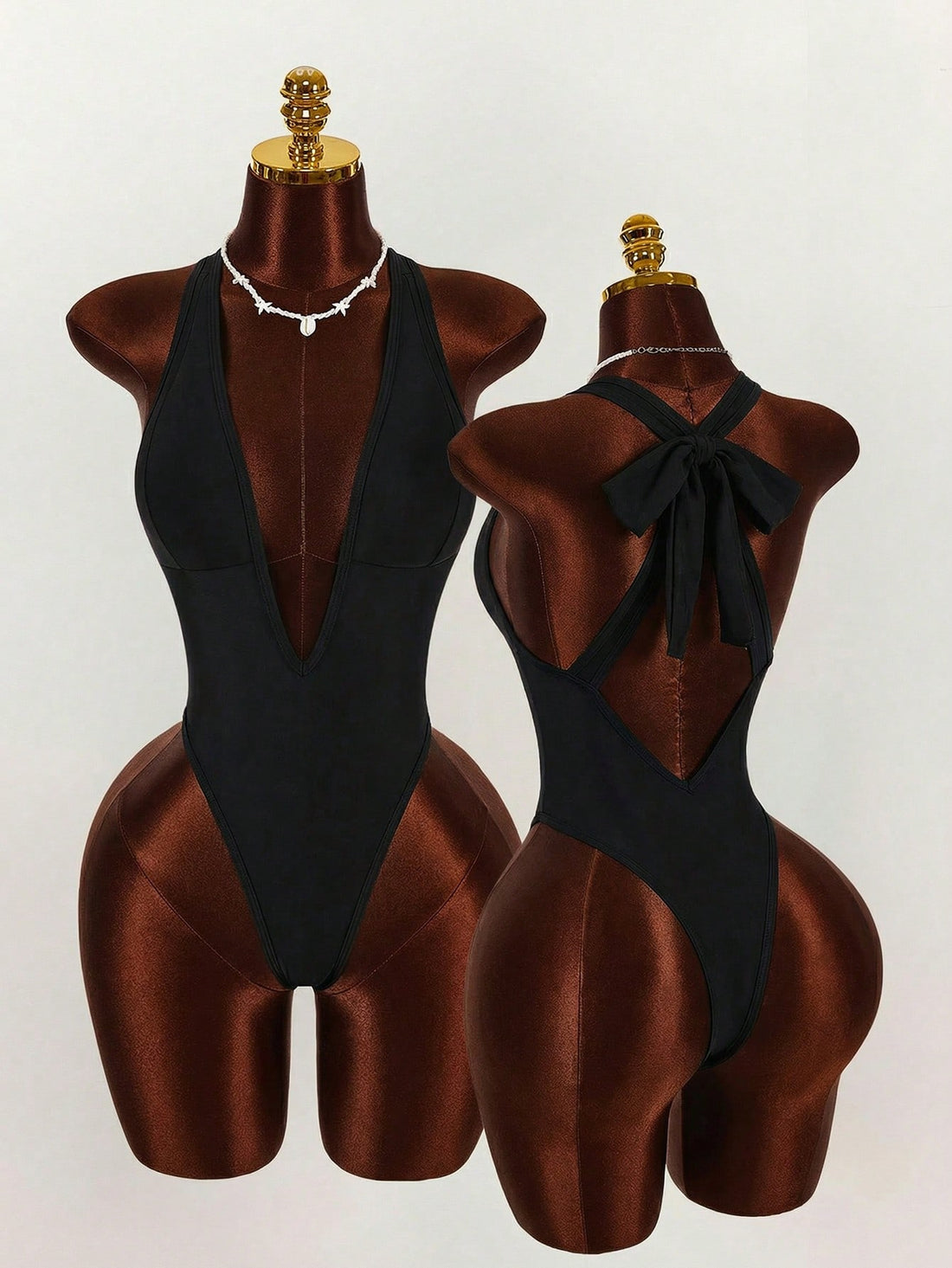Women's elegant black one-piece swimsuit featuring a deep V-neck line, backless design, zipper detail, and high cut silhouette.