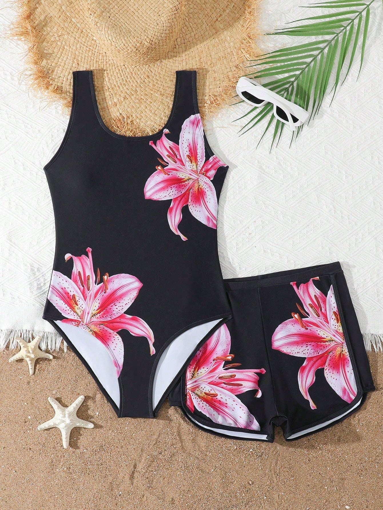 Tween girls 2-piece swimsuit set in black with full floral and plant print, featuring a sleeveless scoop-neck swim top and matching shorts-style bottoms.