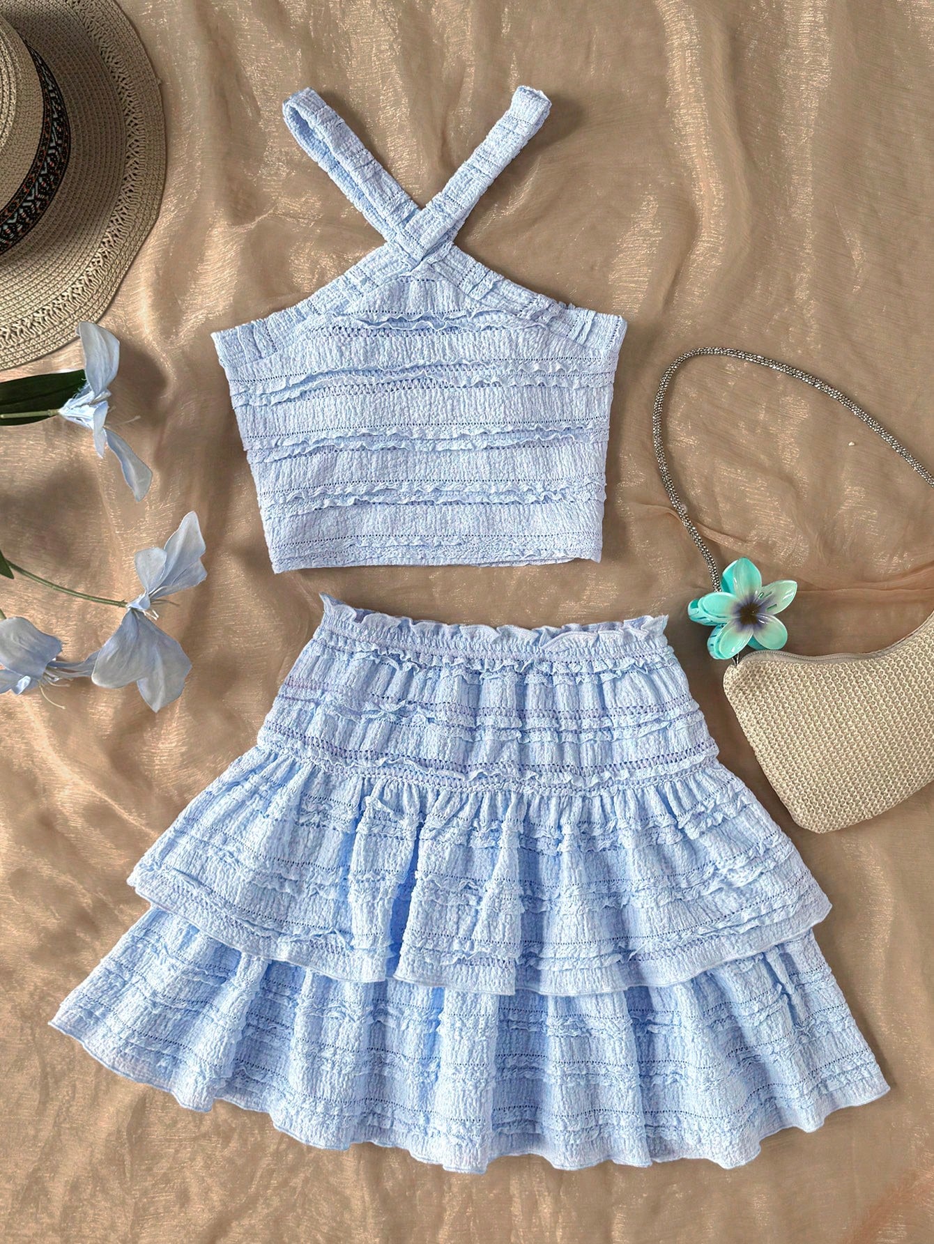 Tween girls blue and white 2-piece set with a striped halter neck vest top and a floral high-waist tiered paperbag skirt.
