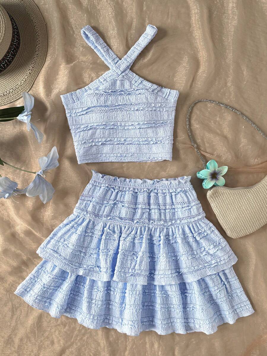 Tween girls blue and white 2-piece set with a striped halter neck vest top and a floral high-waist tiered paperbag skirt.