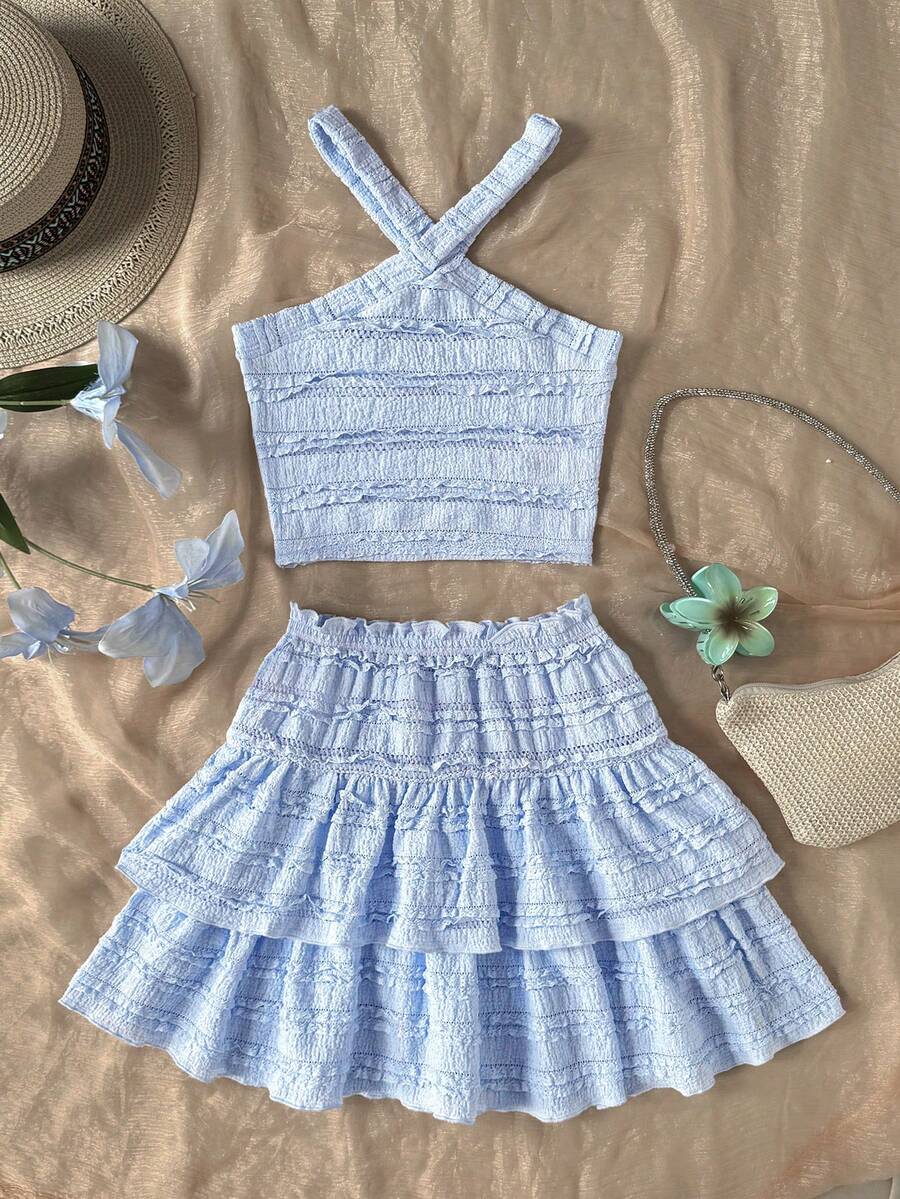 Tween girls blue and white 2-piece set with a striped halter neck vest top and a floral high-waist tiered paperbag skirt.