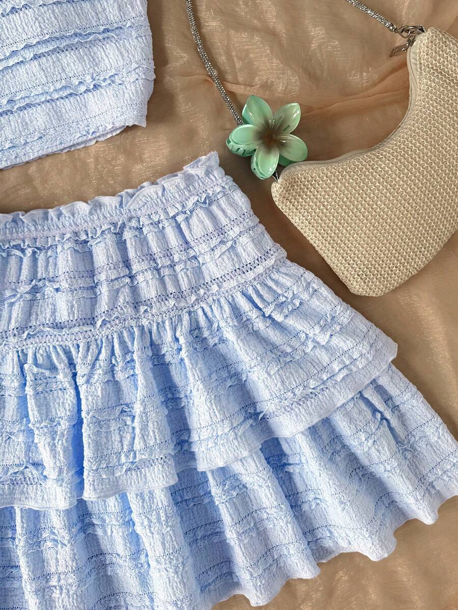 Tween girls blue and white 2-piece set with a striped halter neck vest top and a floral high-waist tiered paperbag skirt.