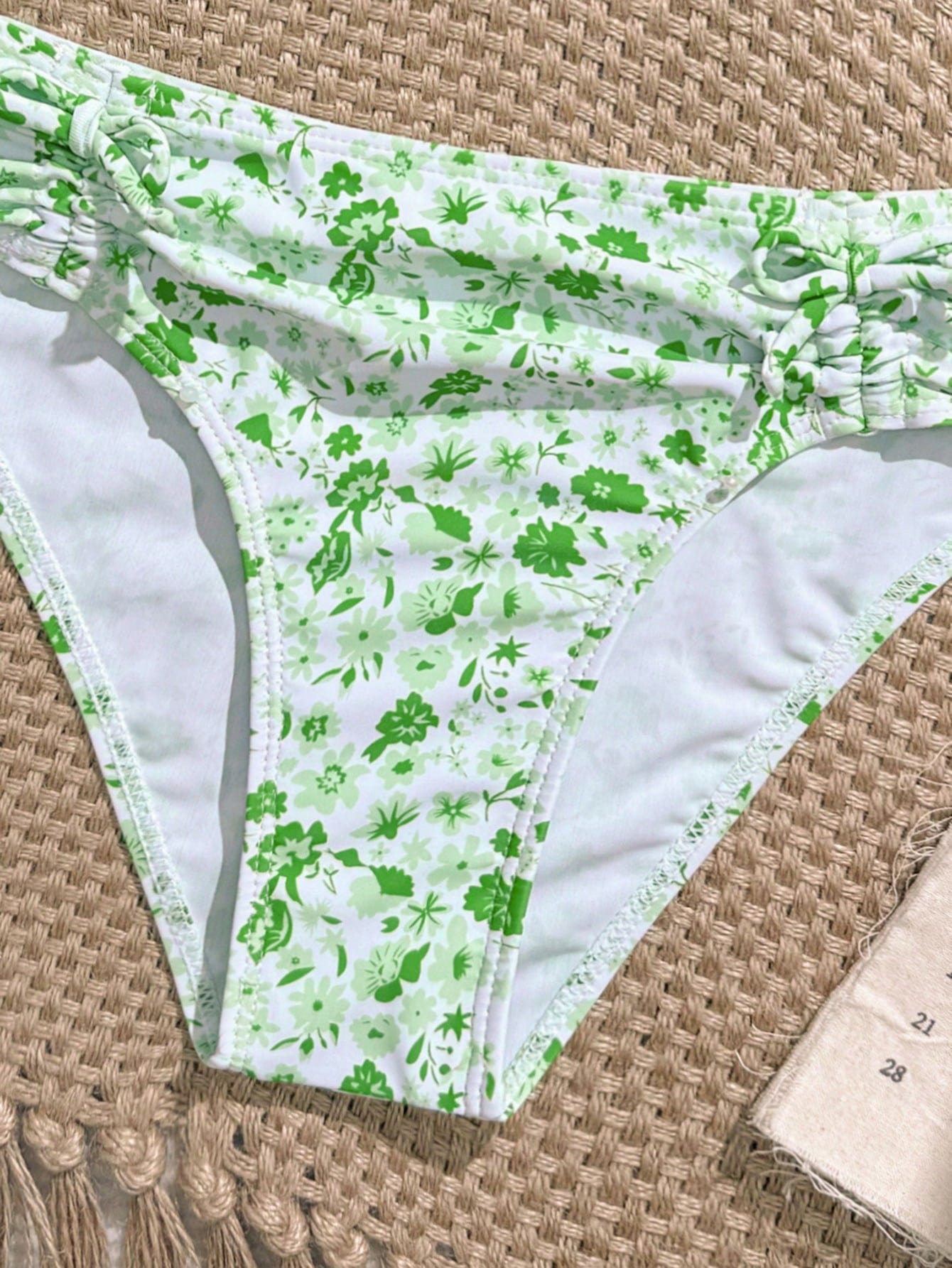 Tween girls 2-piece ditsy floral bikini set featuring a spaghetti strap top with center string detail and matching bottoms with side strings, designed for swimming, vacation, and summer wear.