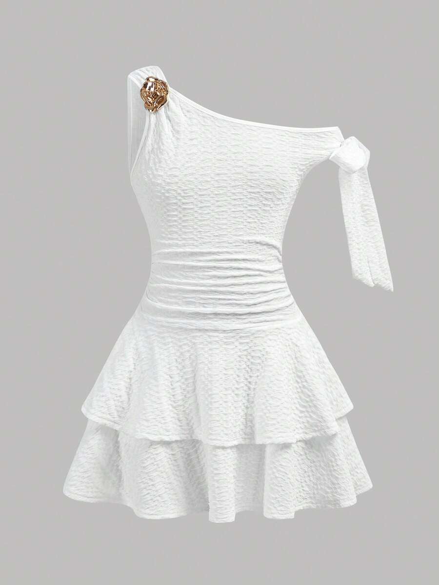 Tween girl wearing an apricot asymmetrical tiered sleeveless party dress with an A-line silhouette.