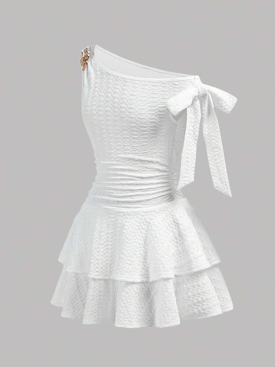 Tween girl wearing an apricot asymmetrical tiered sleeveless party dress with an A-line silhouette.