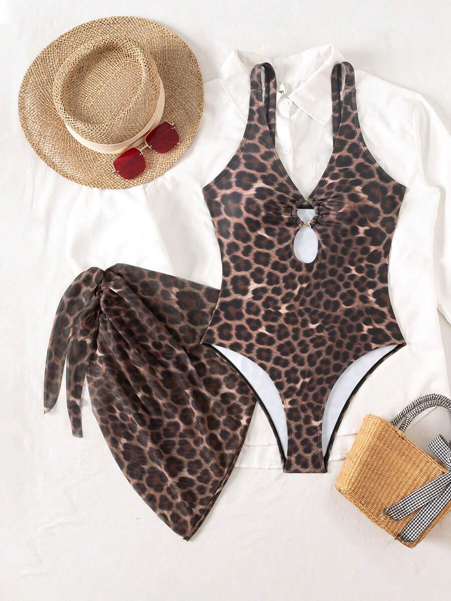 Women's black floral print plunge neck one-piece swimsuit featuring cut-out detail paired with a matching knee-length mesh cover-up skirt