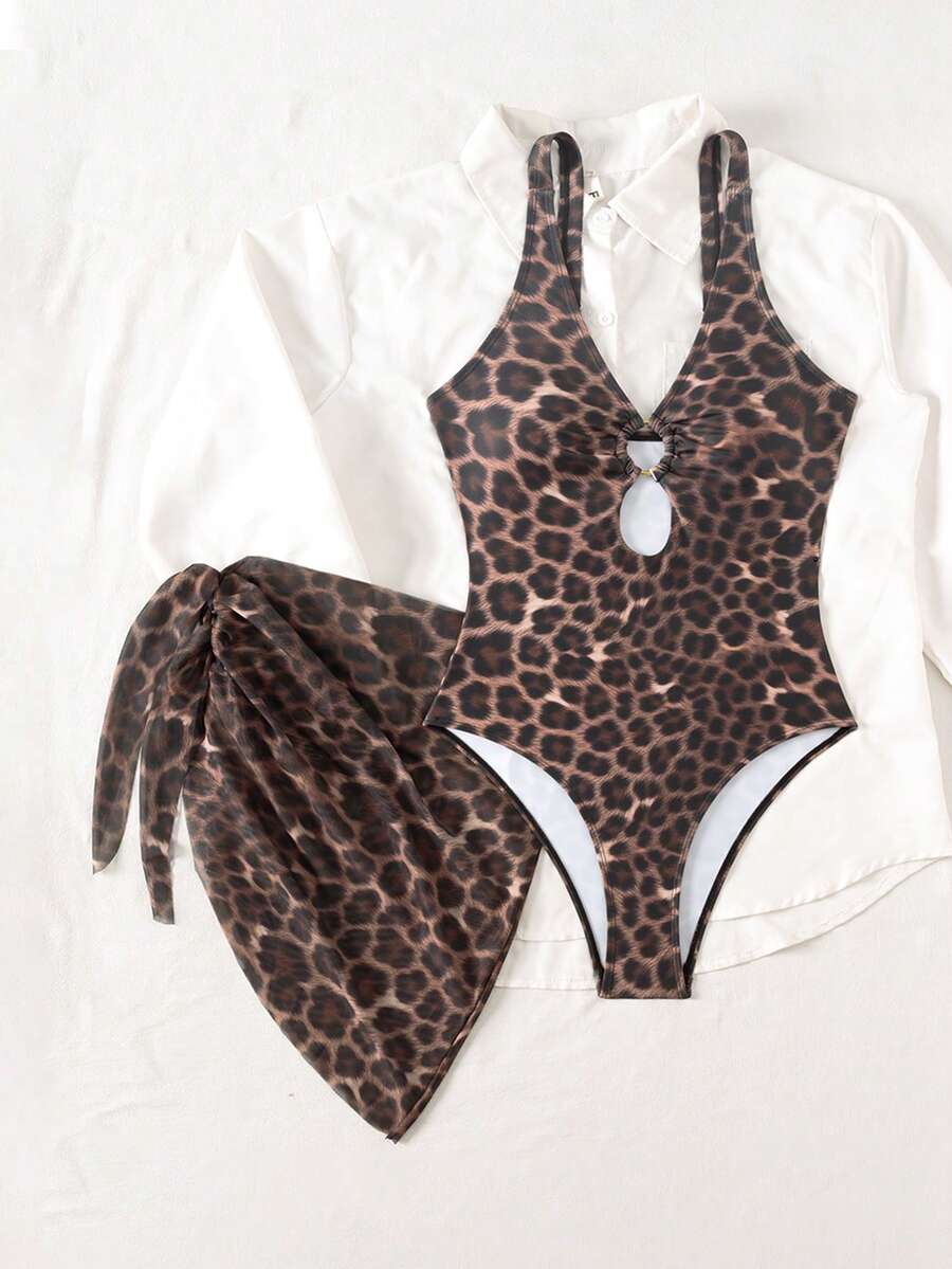 Women's black floral print plunge neck one-piece swimsuit featuring cut-out detail paired with a matching knee-length mesh cover-up skirt