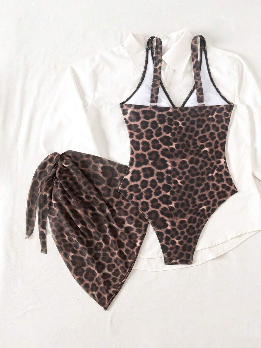 Women's black floral print plunge neck one-piece swimsuit featuring cut-out detail paired with a matching knee-length mesh cover-up skirt