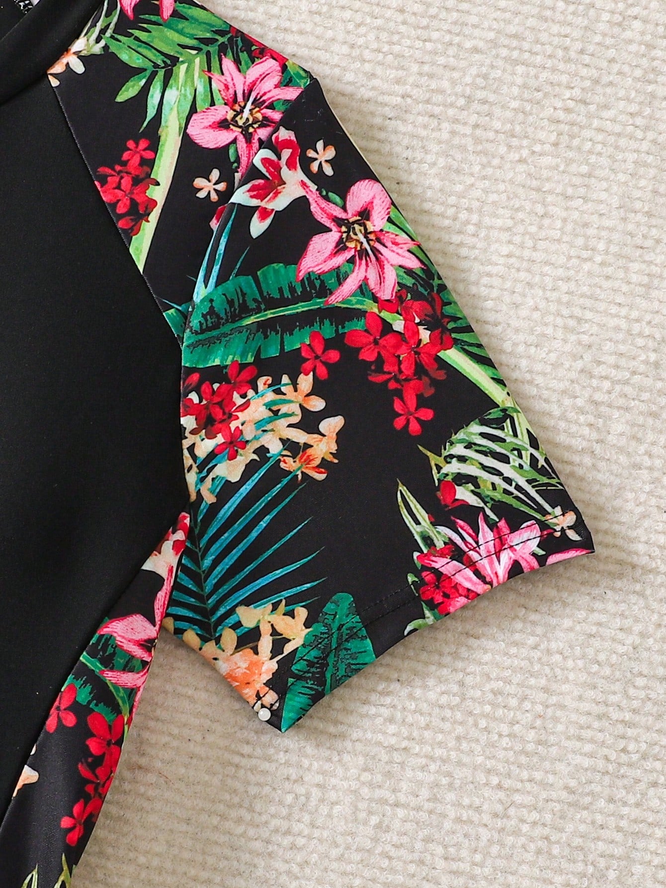 Black and white one-piece rashguard swimsuit for tween girls with short sleeves, high neck, zipper detail, fitted shape, and shorts-style bottom.