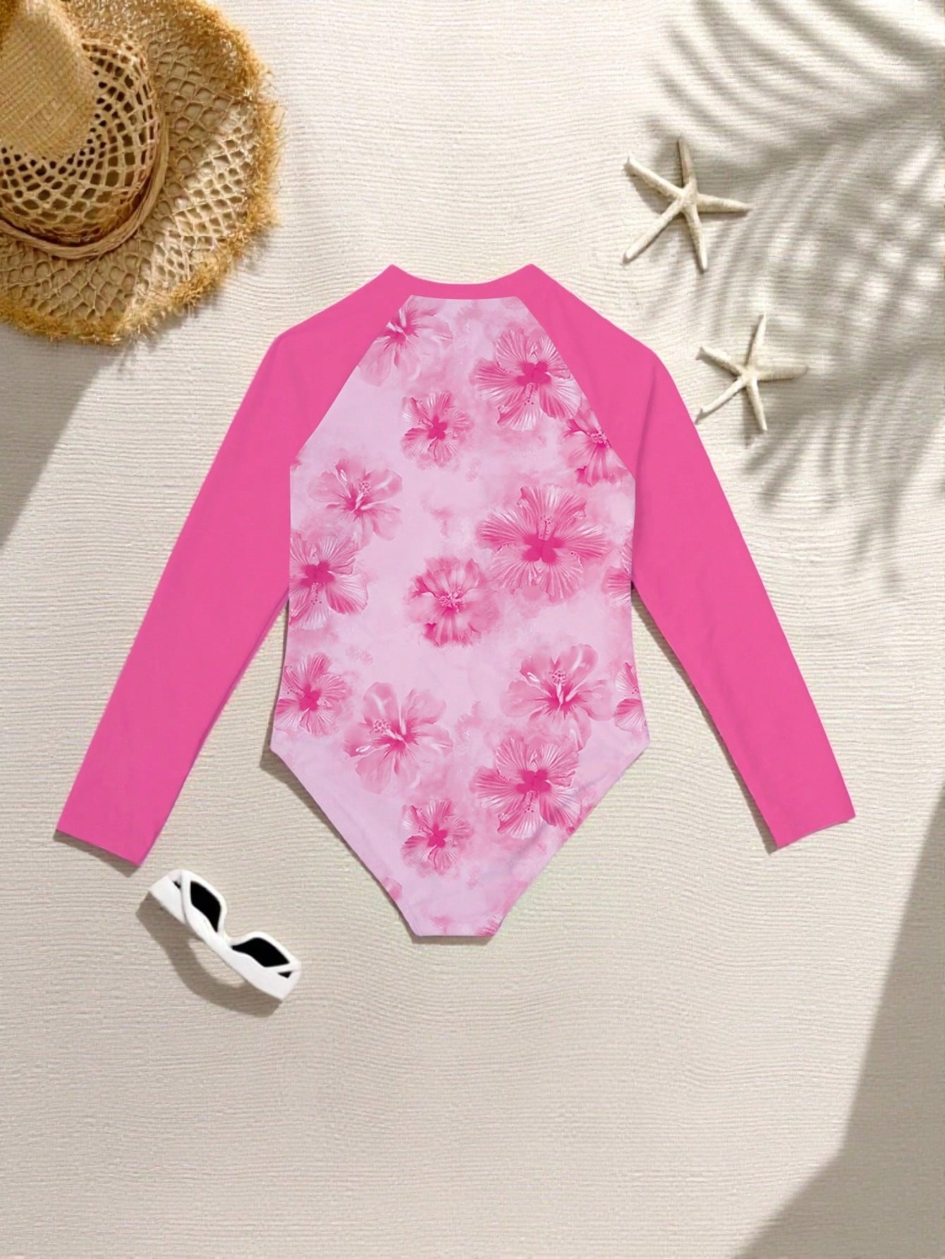 Tween girls one-piece rash guard swimsuit with long sleeves, high neck, front zipper, and ocean shell graphic print in a fitted style for beach, swimming, and vacation wear.