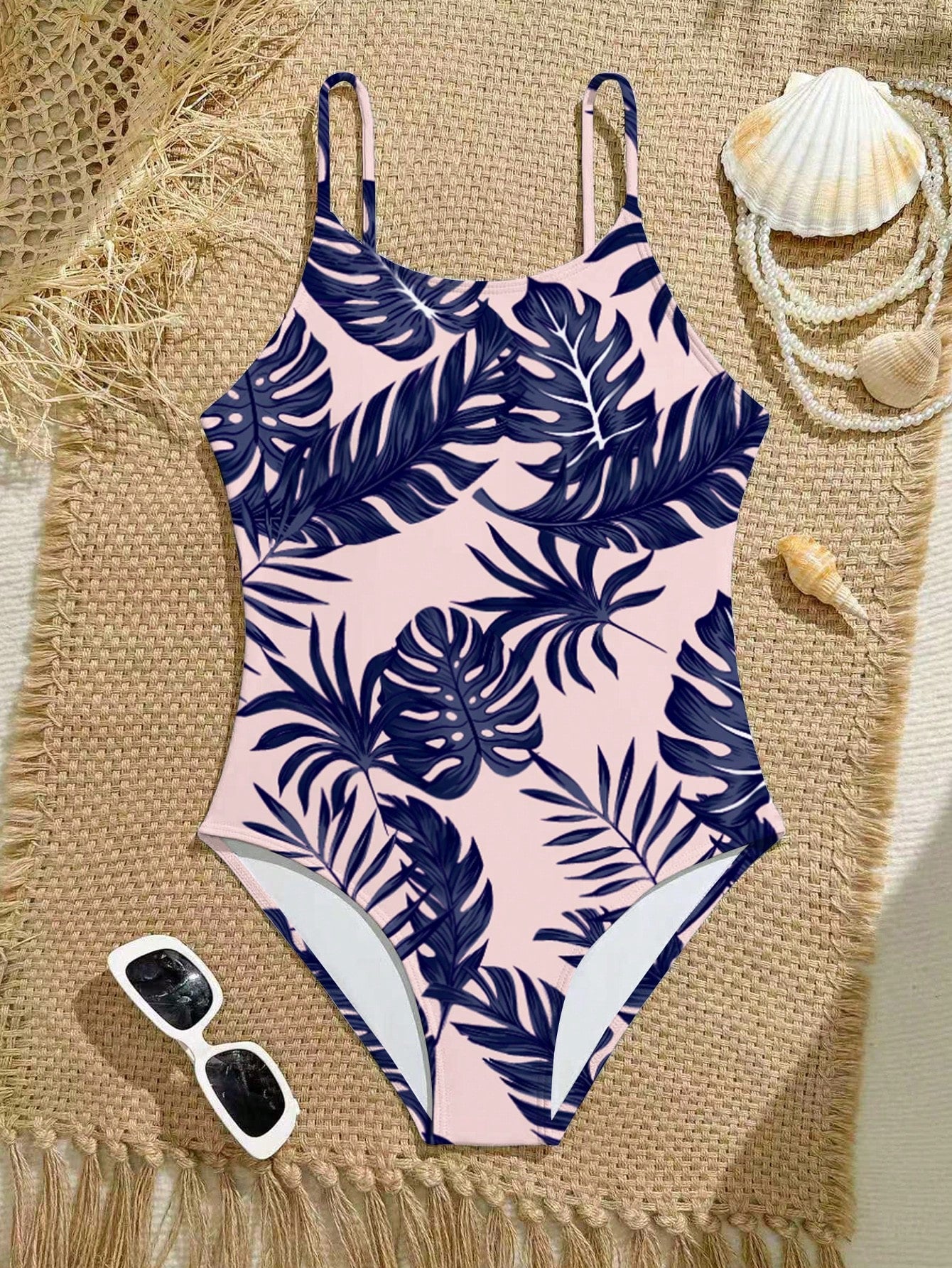 Tween girls one-piece swimsuit with a floral plant print, spaghetti straps, and a mid-waist fit in black.