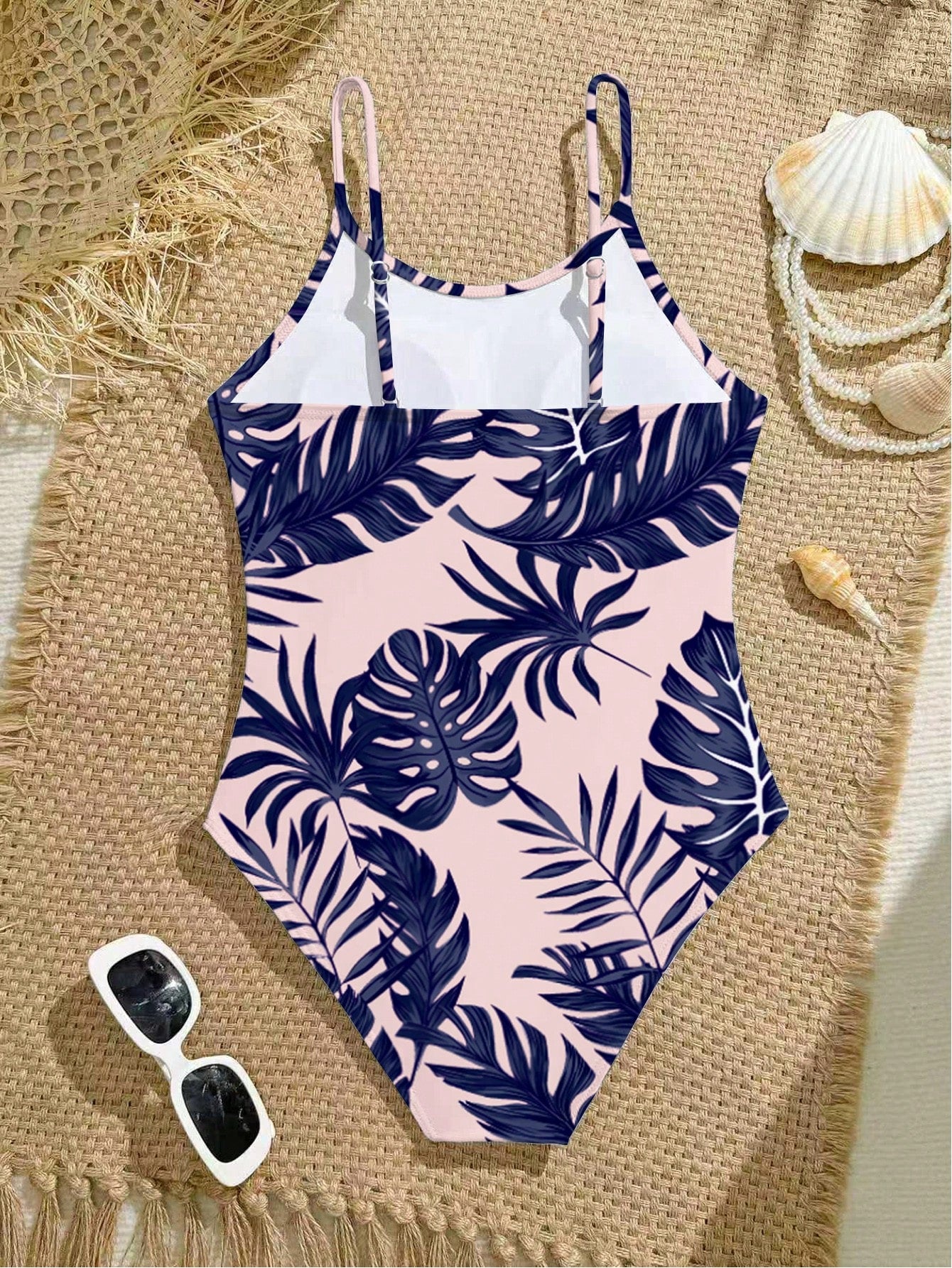 Tween girls one-piece swimsuit with a floral plant print, spaghetti straps, and a mid-waist fit in black.