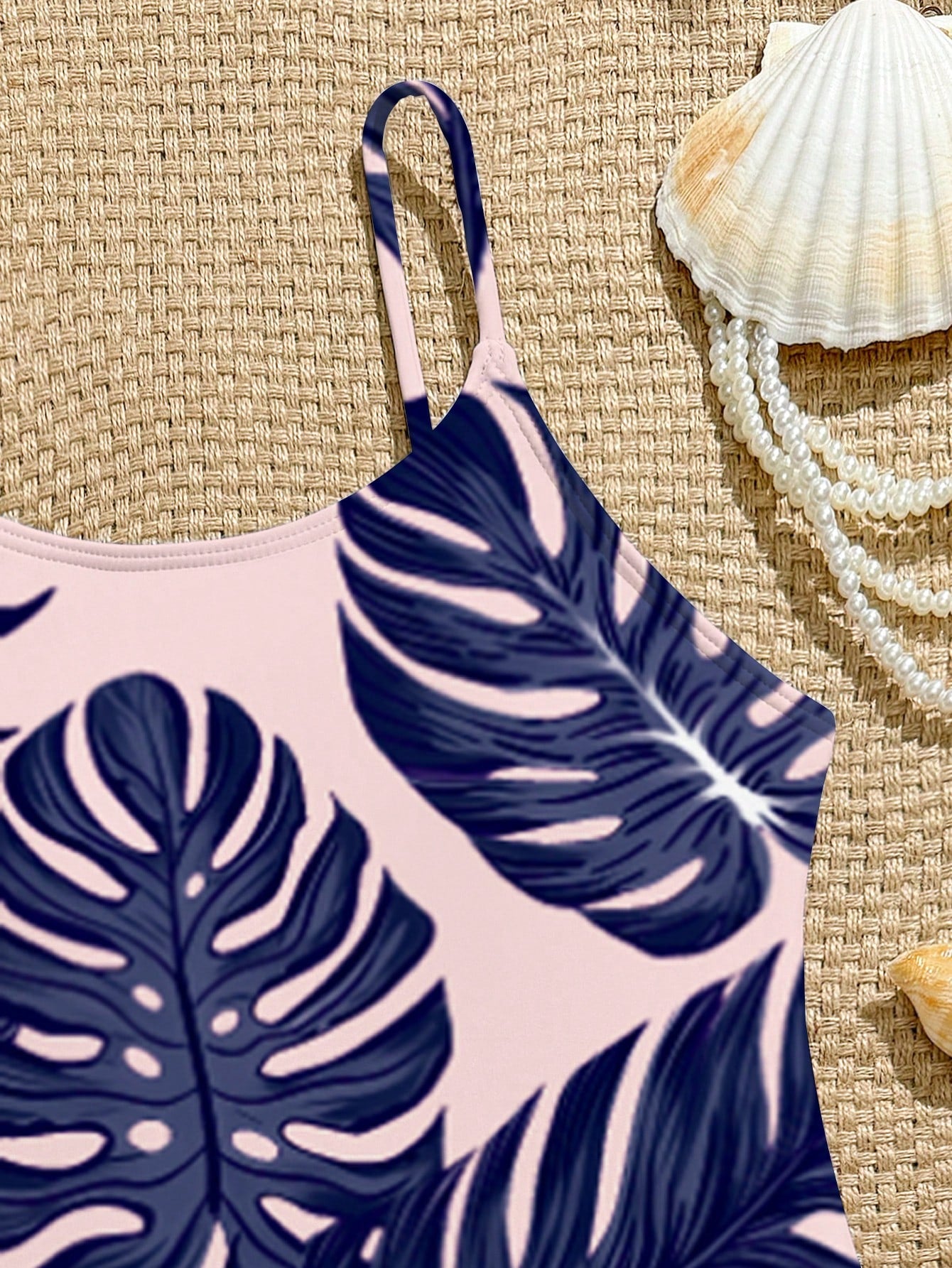 Tween girls one-piece swimsuit with a floral plant print, spaghetti straps, and a mid-waist fit in black.