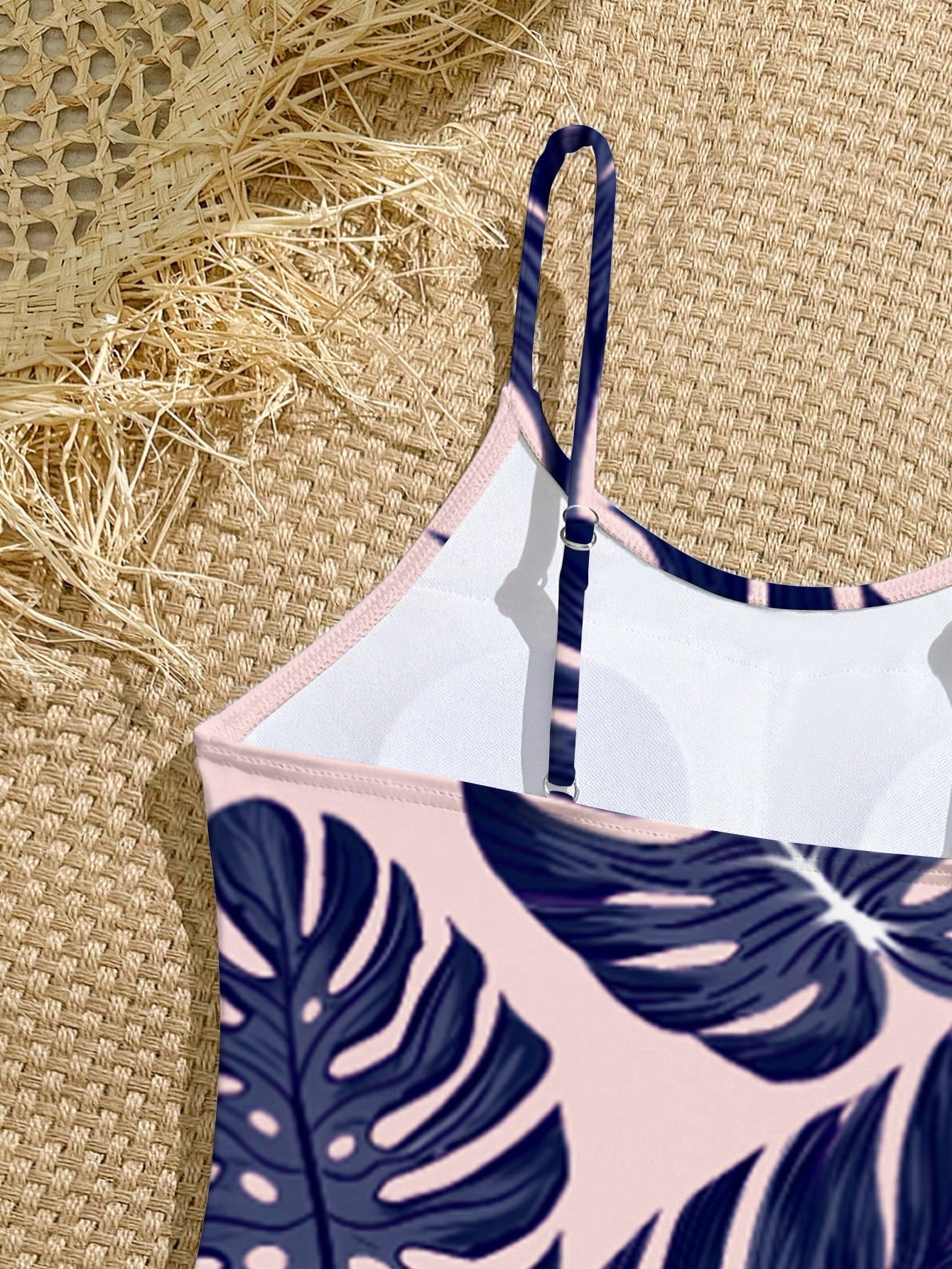 Tween girls one-piece swimsuit with a floral plant print, spaghetti straps, and a mid-waist fit in black.