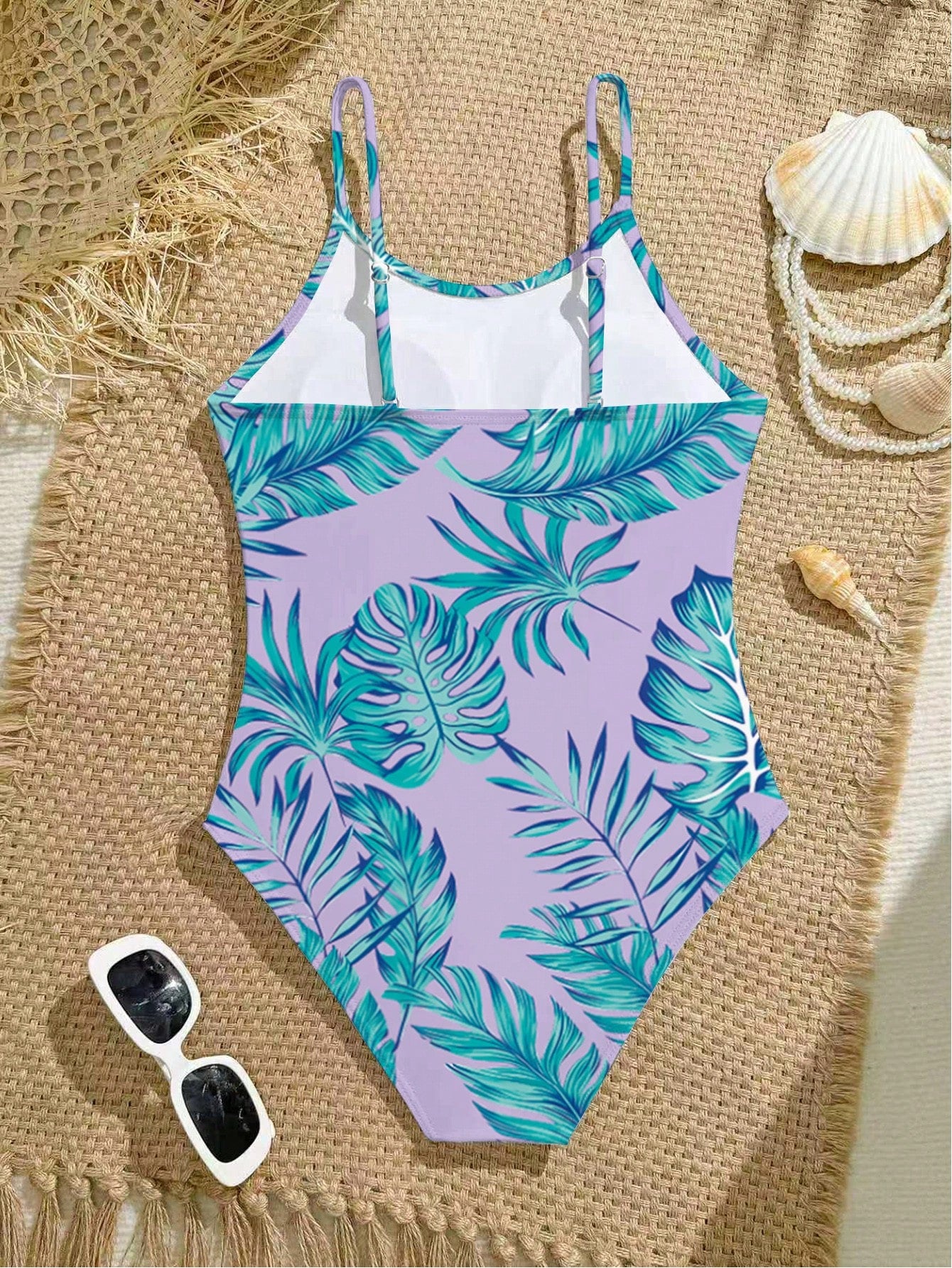 Tween girls one-piece swimsuit with a floral plant print, spaghetti straps, and a mid-waist fit in black.